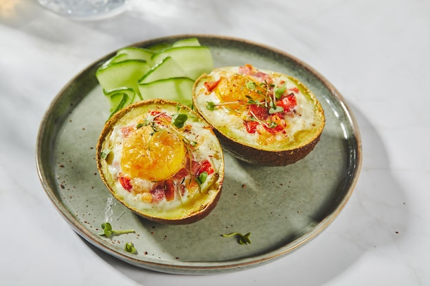 Avocat cuit au four avec des tomates au jambon d'oeuf et une recette de déjeuner céto au fromage après la cuisson