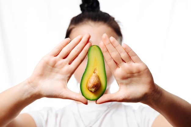 Photo avocat dans une main féminine sur fond blanc