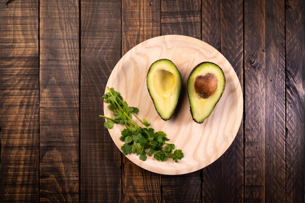 Avocat fendu en deux sur du bois. Nourriture saine et végétarienne