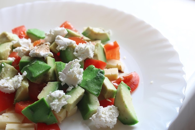 Avocat frais délicieuse salade méditerranéenne avec tomates cerises et amandes et fromage feta Parmesan