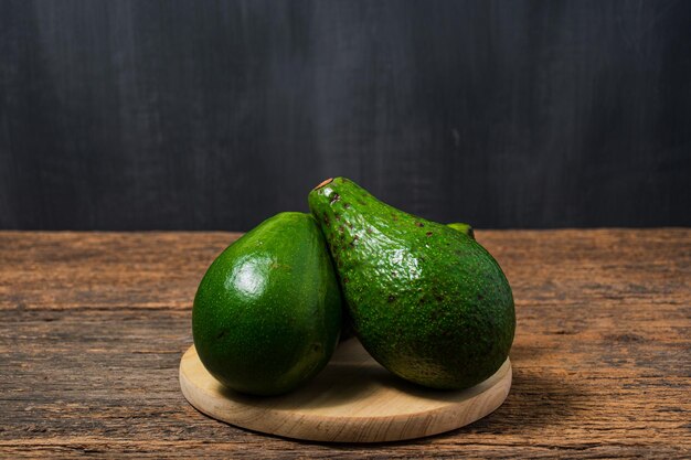 Avocat frais sur une vieille table en bois Avocat vert sur une assiette en bois Fruits concept d'alimentation saine