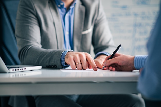 Avocat montrant à un client où signer un document juridique, gros plan.