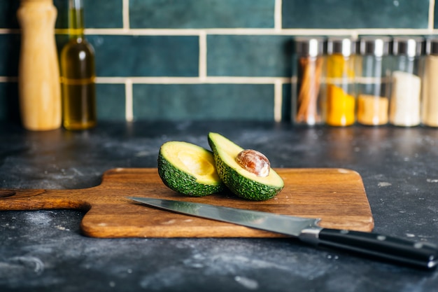 Avocat sur la table de la cuisine. Cuisine et smoothies à l'avocat dans la cuisine à domicile. Vitamines et concept de saine alimentation