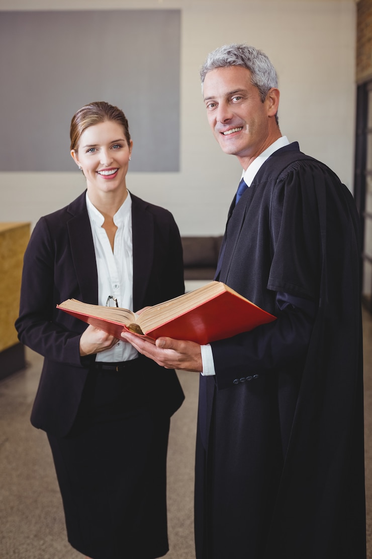 Photo un avocat tenant un livre tout en se tenant avec une collègue