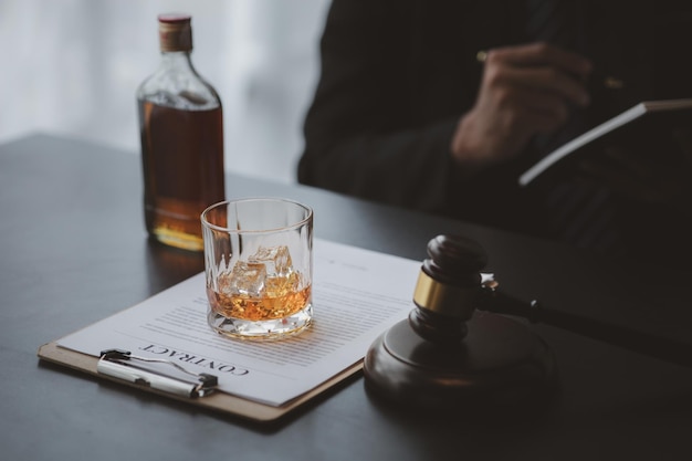 Un avocat tenant un verre de whisky Il est dans son bureau et il insiste sur le fait de plaider pour un client, il est avocat Le concept de litige juridique clair