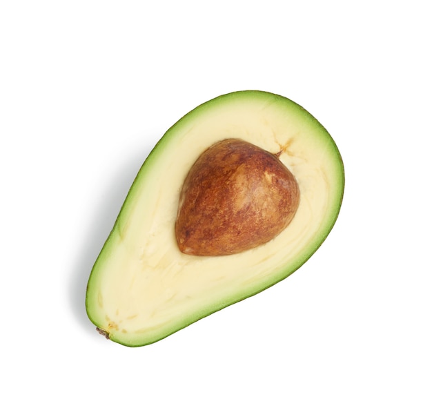 Avocat vert à moitié mûr avec un noyau brun isolé sur fond blanc, fruits sains et savoureux, vue du dessus