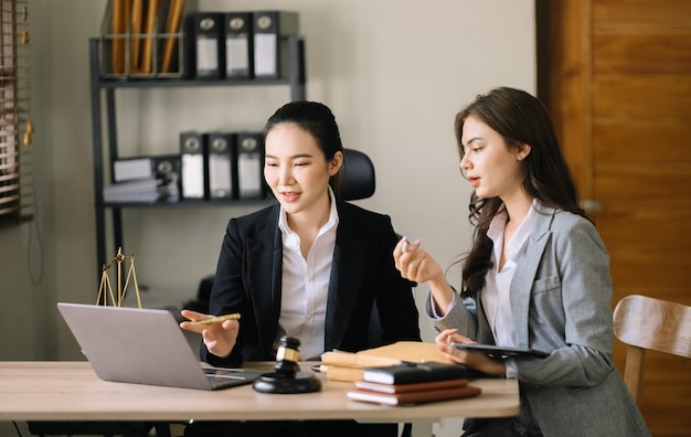 Une avocate ou une juge d'affaires et une femme consultent une réunion d'équipe avec le client Concept de services juridiques et juridiques Service à la clientèle bonne coopération au bureau