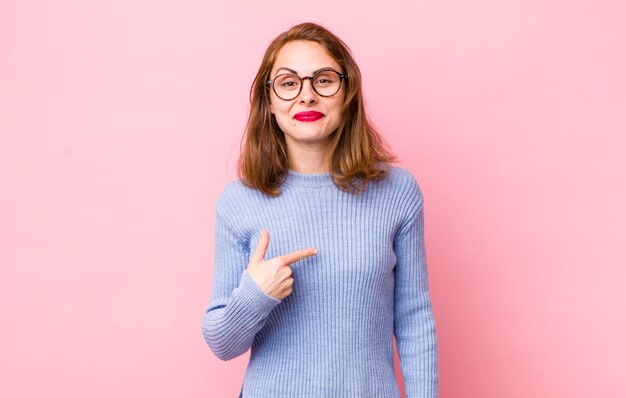 Avoir l'air fier, confiant et heureux, souriant et pointant vers soi-même ou faisant le signe numéro un