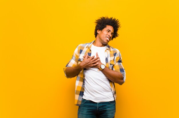 avoir l'air triste, blessé et le cœur brisé, tenir les deux mains près du cœur, pleurer et se sentir déprimé