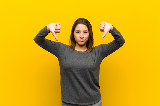 avoir l'air triste, déçu ou en colère, montrer les pouces vers le bas en désaccord, se sentir frustré