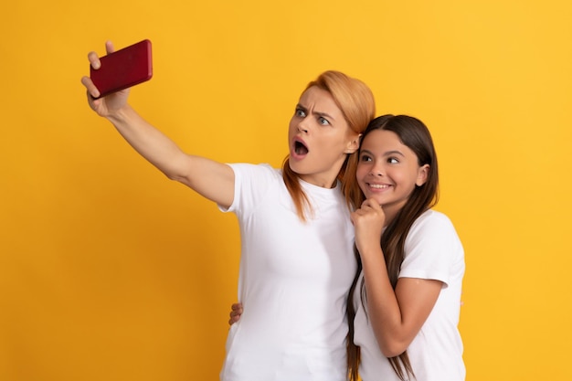 Avoir un appel vidéo mère et fille vlogging communication en ligne maman et enfant blogging sympathique femme et fille posant pour selfie sur téléphone mobile selfie famille vie moderne technologie mobile