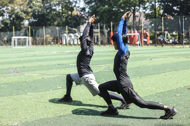 Avoir un bon étirement. Deux jeunes hommes asiatiques portant des vêtements de sport s'étirant tout en s'échauffant sur le cou