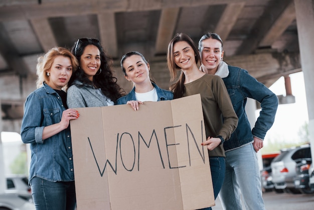 Avoir de la bonne humeur. Un groupe de femmes féministes protestent pour leurs droits en plein air