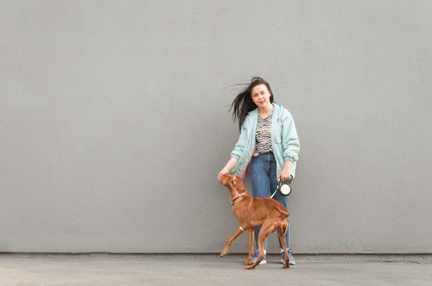 Avoir une femme brune en tenue décontractée avec un chien