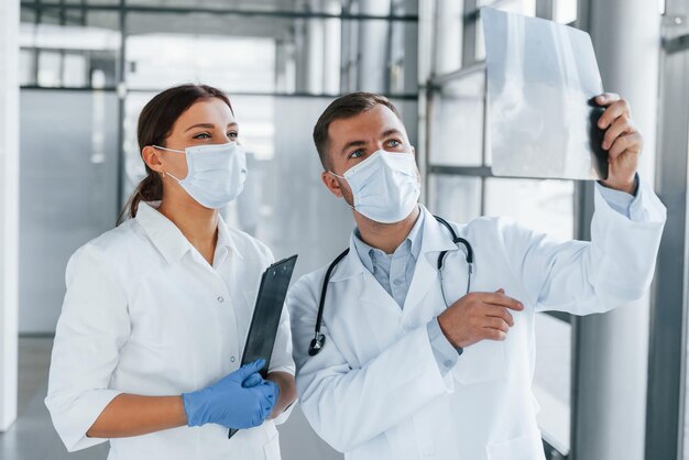 Avoir une journée bien remplie Deux médecins en blouse blanche travaillent ensemble à la clinique