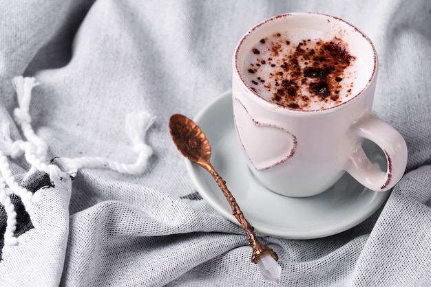 Avoir une tasse de café au chocolat sur une couverture au lit
