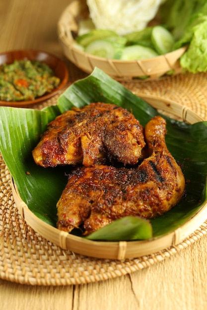 Ayam Bakar Poulet grillé traditionnel indonésien Disposé sur un plateau en bambou avec concombre