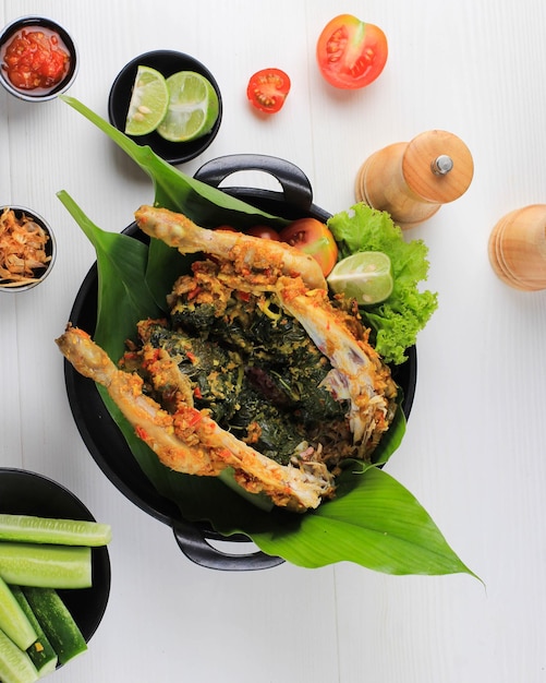 Ayam Betutu. Poulet rôti balinais farci aux feuilles de manioc.