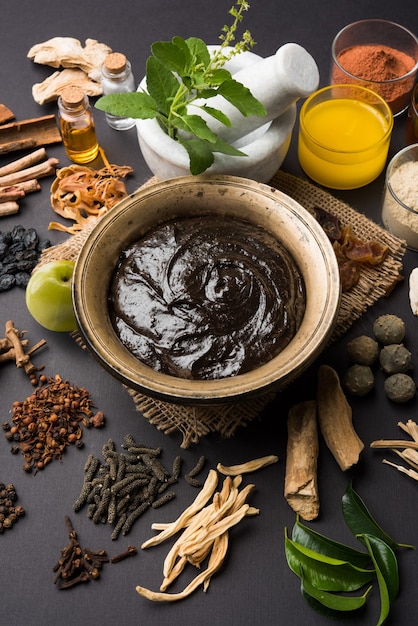 Ayurvedic Chyawanprash est un puissant booster d'immunité OU un supplément de santé naturel. Servi dans un bol antique avec des ingrédients, sur fond de mauvaise humeur, mise au point sélective