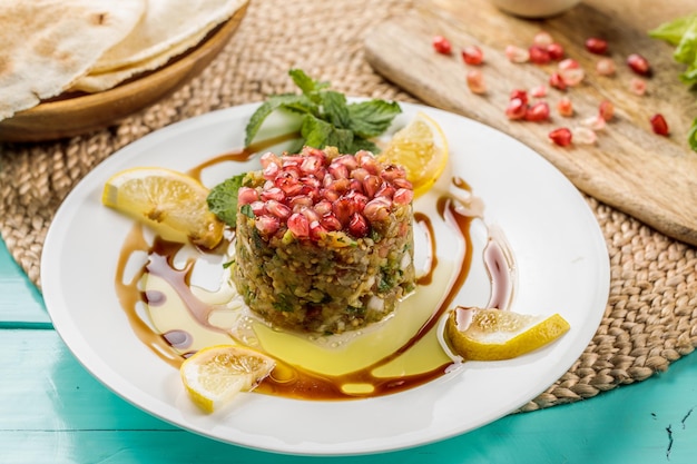 Baba Ghanouj avec tranche de citron servi dans un plat isolé sur la vue latérale de la planche à découper