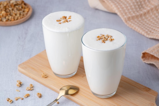 Babeurre au kéfir ou yaourt avec granola Yogourt en verre sur fond de bois blanc Espace de copie