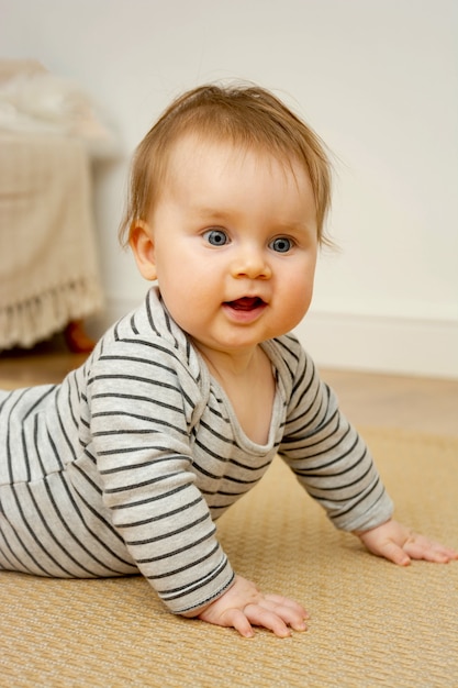 Baby gir aux yeux bleus apprenant de nouvelles compétences.