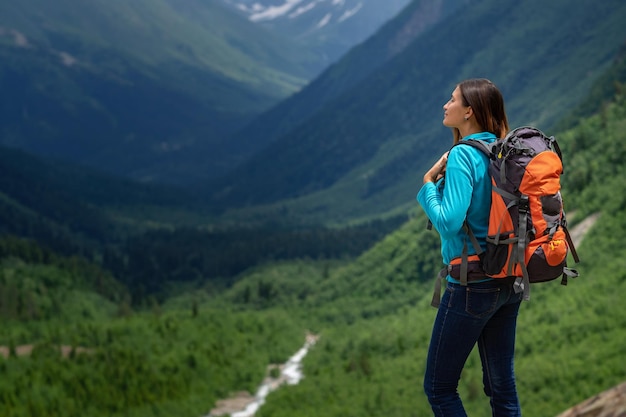 Backpacker au sommet d'une montagne avec vue sur la vallée