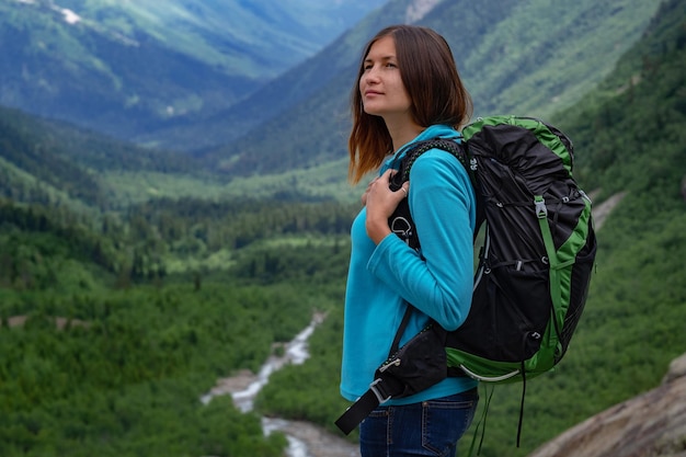 Backpacker au sommet d'une montagne avec vue sur la vallée