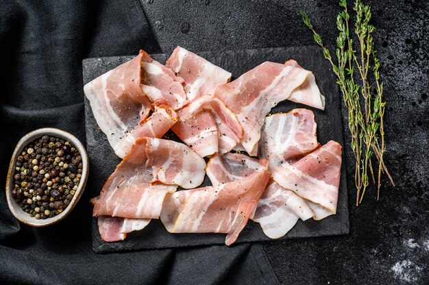 Bacon de porc fumé au poivre et au thym. Viande crue biologique. Vue de dessus