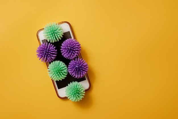 Les bactéries du coronavirus sur téléphone sur une vue de dessus de fond jaune