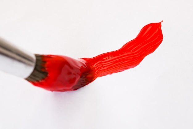 Badigeonner de peinture rouge sur une feuille de papier