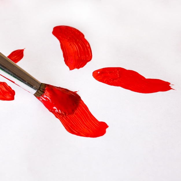 Badigeonner de peinture rouge sur une feuille de papier