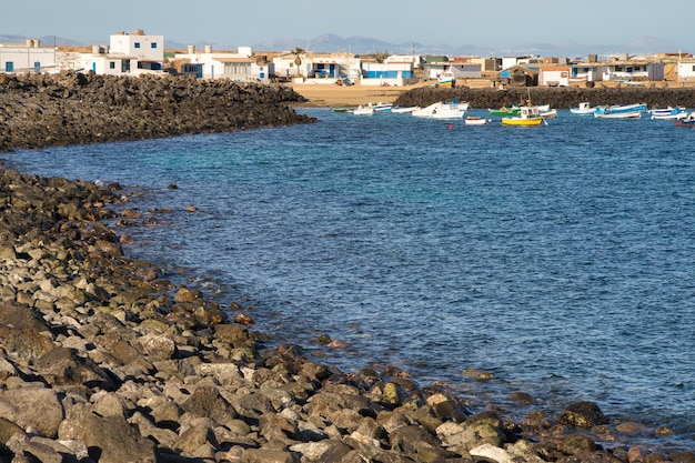 Badlands plage de pierres sombres avec Puerto Lajas en arrière-plan sur l'île de Fuerteventura