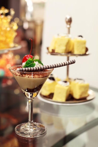 Photo bagatelle crémeuse au chocolat dans des verres à cocktail avec des cerises rouges et du chocolat