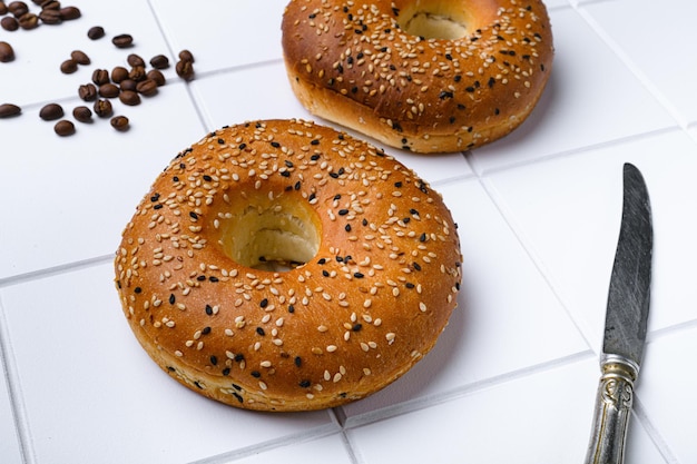 Bagel fraîchement cuit au four sur fond de table en carreaux de céramique blanche