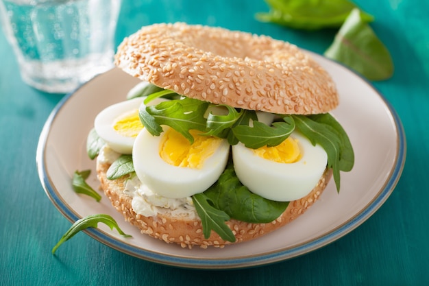 Bagel de petit déjeuner avec œuf, fromage à la crème et roquette