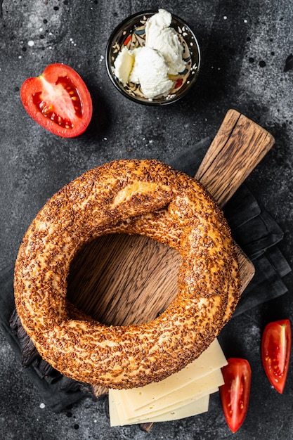 Bagel Simit ou Gevrek sur planche de bois pour la cuisson des sandwichs Fond noir Vue de dessus