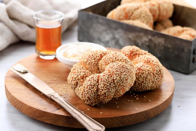 Bagel traditionnel turc croustillant (Simit) avec sésame et verre de thé noir turc sur fond de bois, concept de pâtisserie de petit déjeuner turc