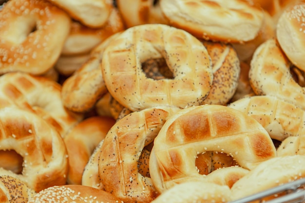 Bagels traditionnels faits maison au sésame prêts à l'emploi dans un plateau avec une pince dans la boulangerie sélectionnez