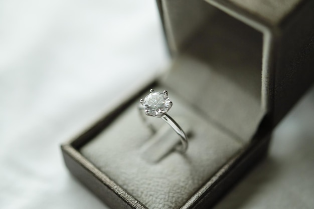 Bague en diamant avec boîte-cadeau de bijoux sur fond de tissu blanc