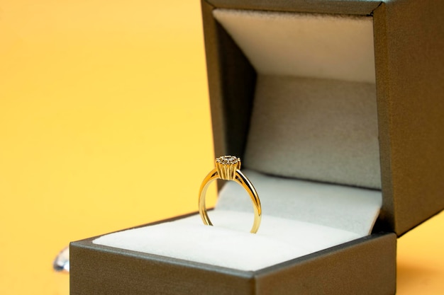 Bague en diamant dans une boîte-cadeau de bijoux sur fond jaune