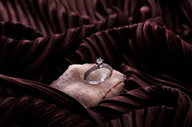 Une bague en diamant repose sur un morceau de tissu.