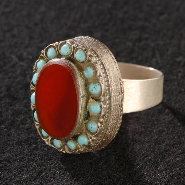 Une bague fantaisie vintage avec pierre rouge précieuse isolée sur fond noir