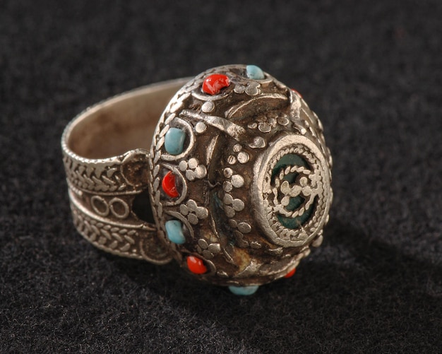 Une bague fantaisie vintage avec des pierres précieuses colorées isolées sur fond noir