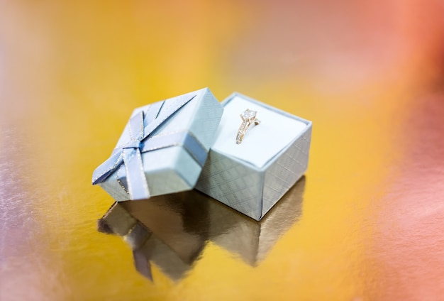 Bague de fiançailles en or dans une boîte cadeau en argent
