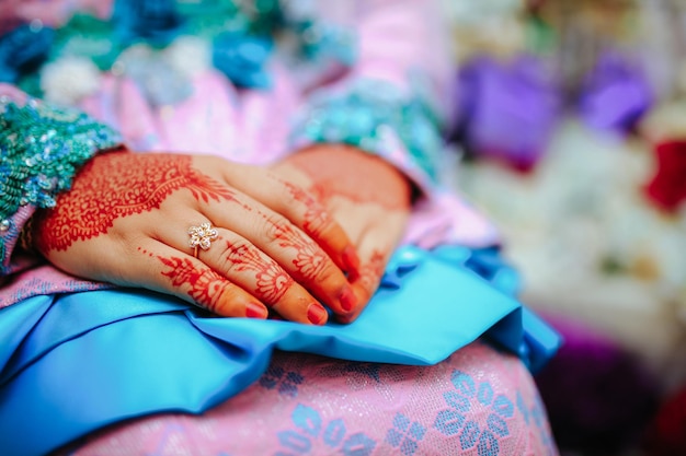 Photo une bague de mariage et du henné sur le doigt de la mariée.