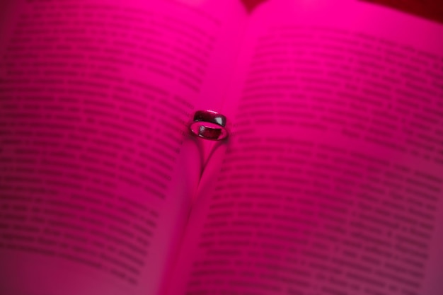 Bague de mariage à livre ouvert et ombre en forme de coeur La lumière au néon rose illumine les pages