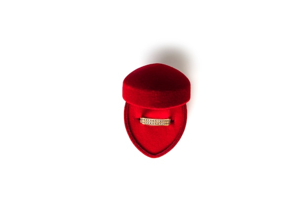 Bague de mariage en or dans une boîte à bijoux en forme de coeur rouge isolée sur fond blanc. photo de haute qualité