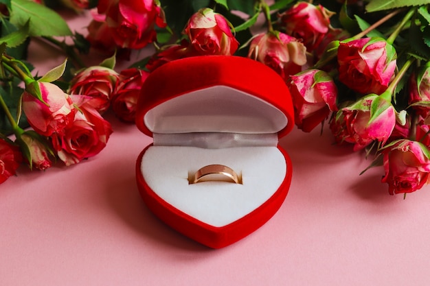 Bague de mariage en or dans une boîte cadeau entourée de fleurs.Concept de proposition, mariage, amour, Saint Valentin