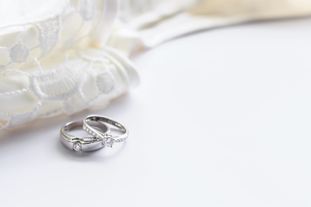 Bague de mariage sur une table blanche avec un flou artistique et plus de lumière en arrière-plan